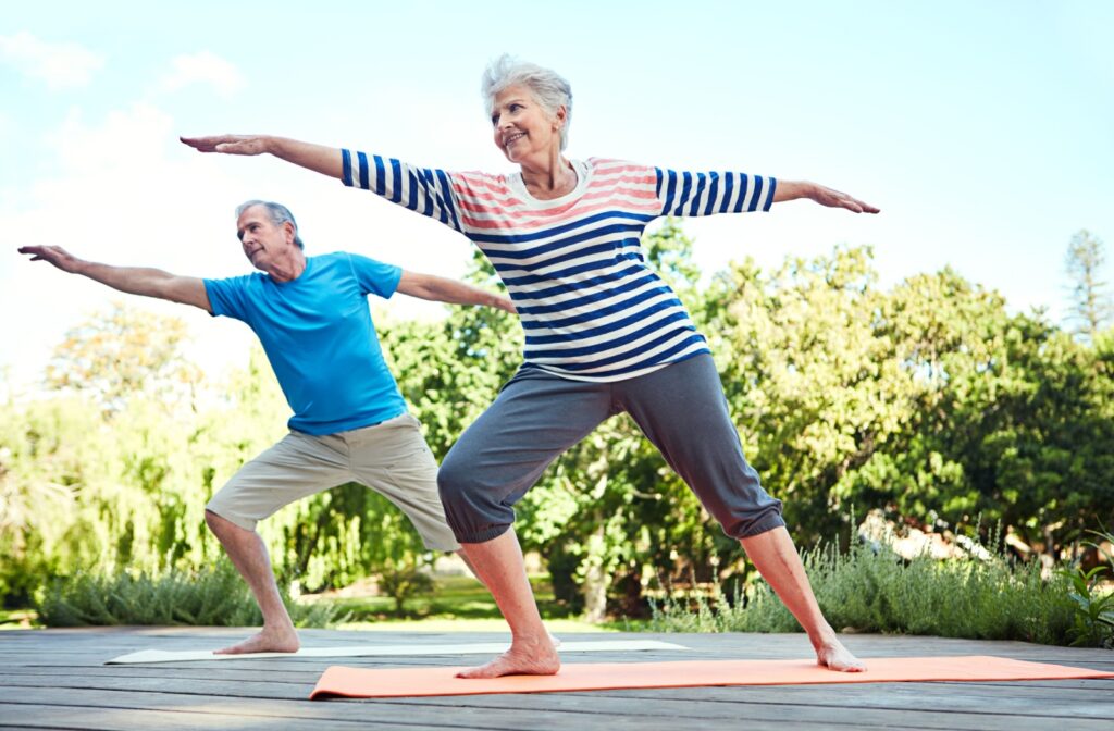 A senior couple doing balance exercises out in the garden