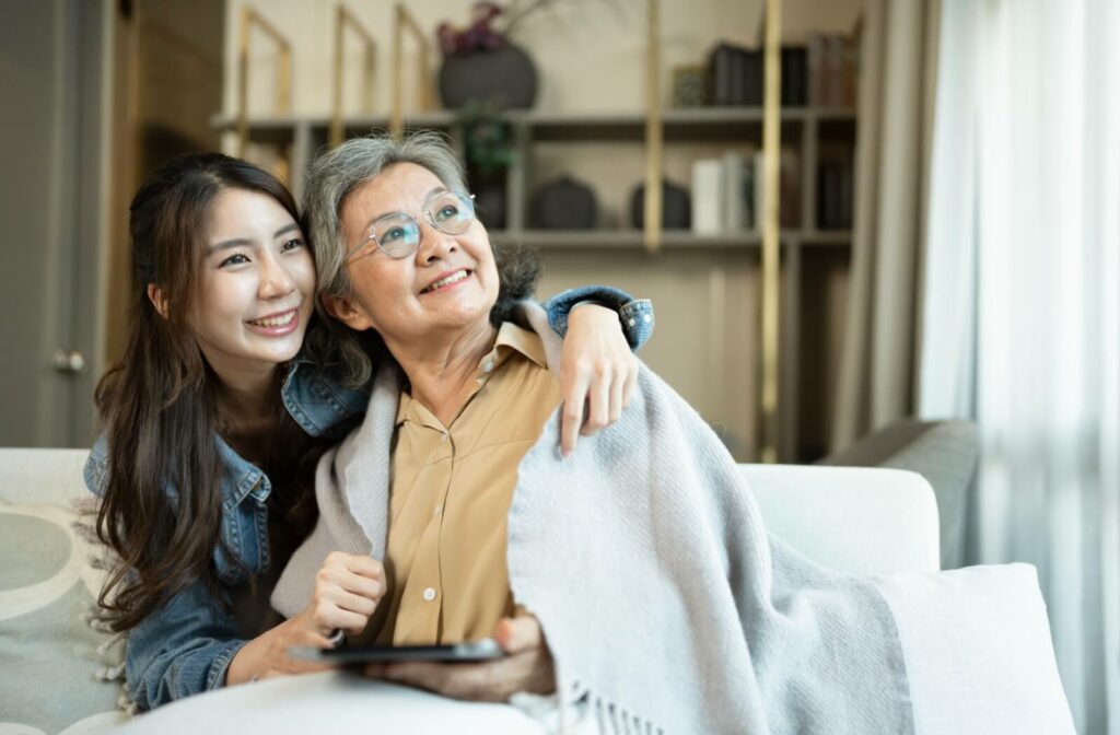 An adult child visits their senior parent in assisted living, excited to have more time to bond
