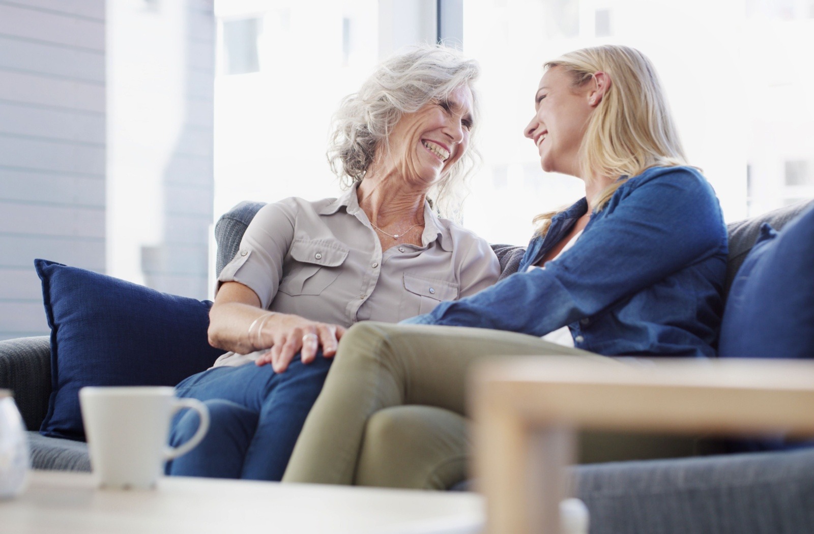 A senior and their younger loved one smile at each other