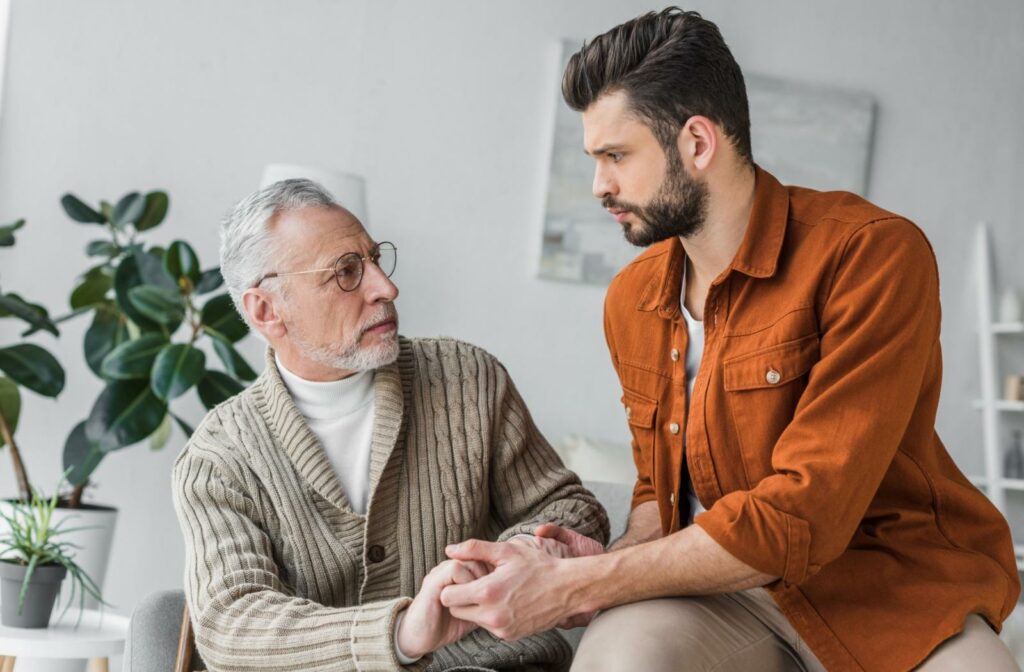 a senior and their child speak while sitting on a couch